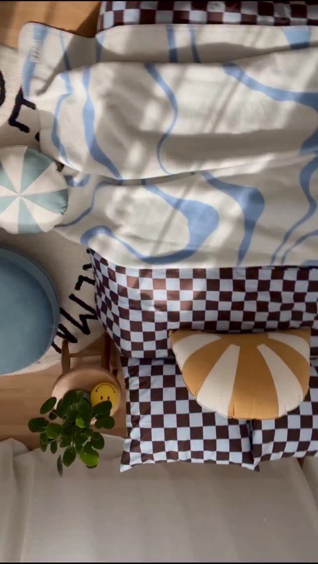 Playful patterned cushions arranged together on a children’s bed.